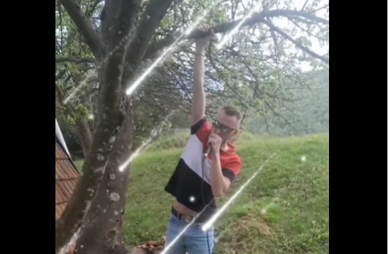 "SA JABUKE SPECIJALNO" Mladić pjeva okačen jednom rukom o granu drveta, a u drugoj drži mikrofon (VIDEO)