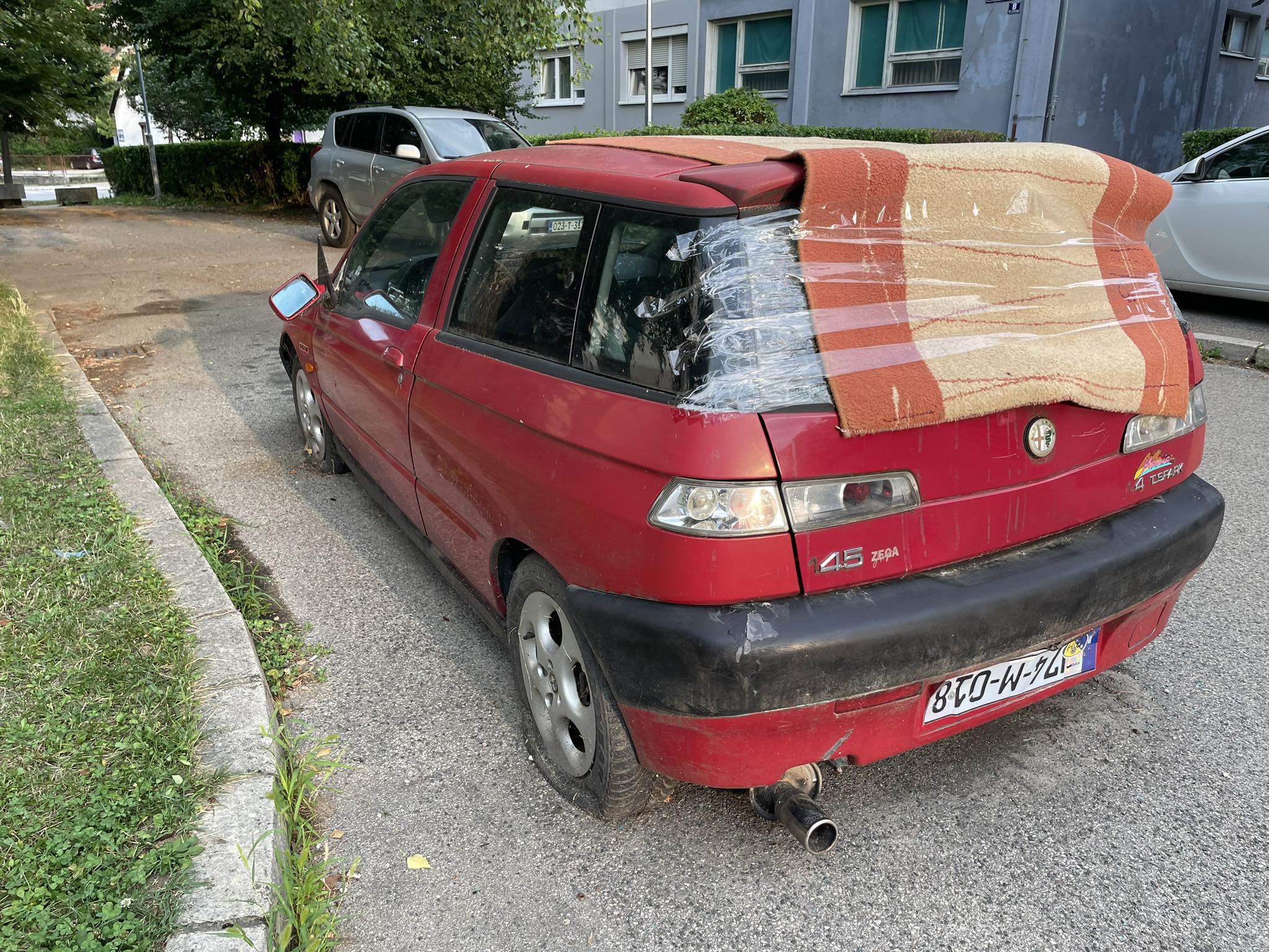 OVO IMA SAMO KOD NAS! Tepih na gepeku, tablica okrenuta naopačke, polomljeni retrovizori, probušene gume i "50 nijansi crvene": Ovakav auto sigurno niste vidjeli! (FOTO)